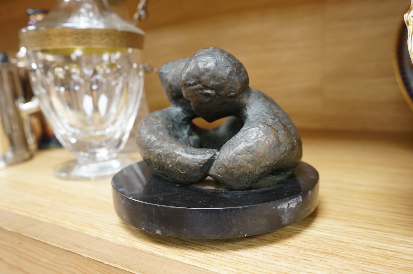 A contemporary bronze revolving sculpture of an embracing couple, unsigned, 16cm in diameter